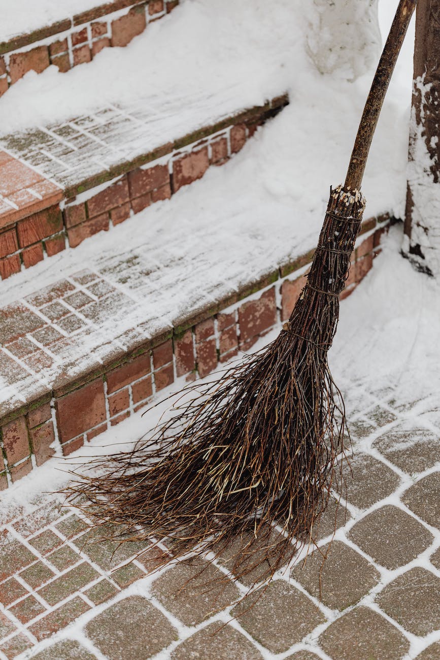 brown broom leaning on stone pavement
